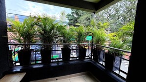 A balcony with potted plants, a view of a street, and a sign reading "Enviado Ave El Pueblo". - LUXURY POBLADO PARK (Medellín)