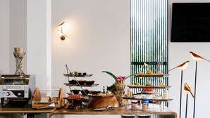 Montaje tipo bufé con diversas opciones de comida y una máquina de café.