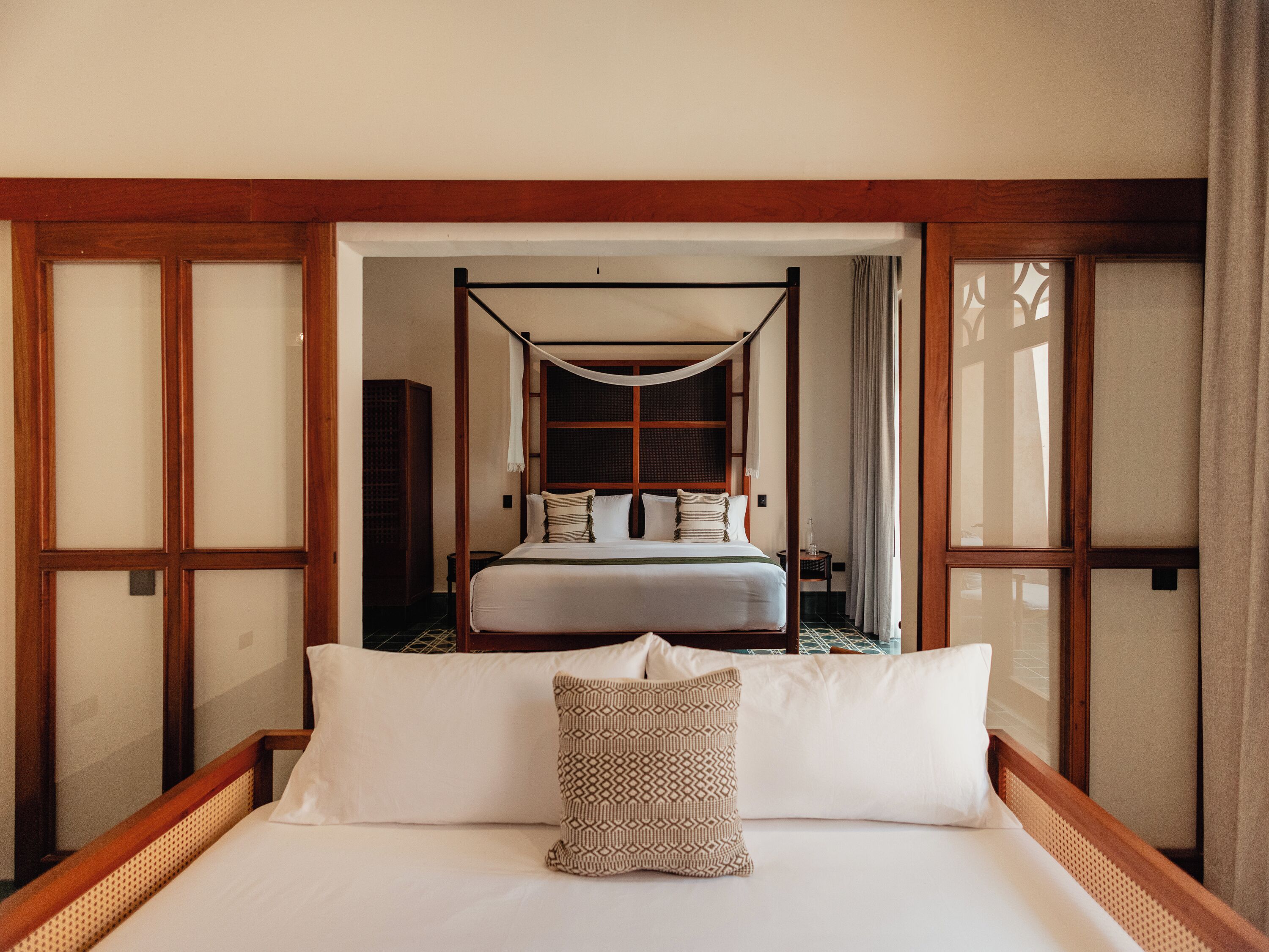 A traditional Japanese-style room with a bed, a futon, and sliding doors.