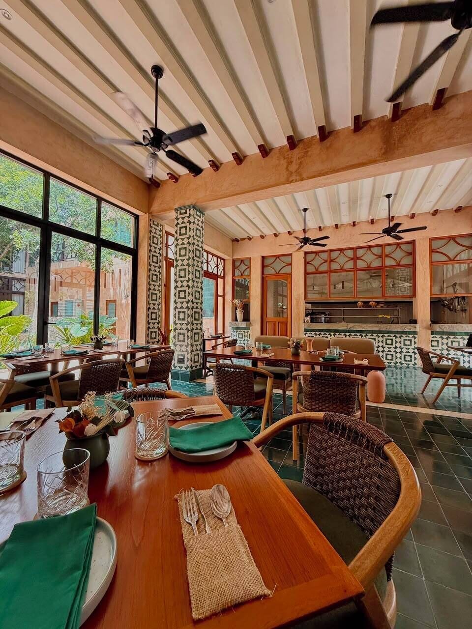 A dining area with a wooden table, chairs, and ceiling fans.