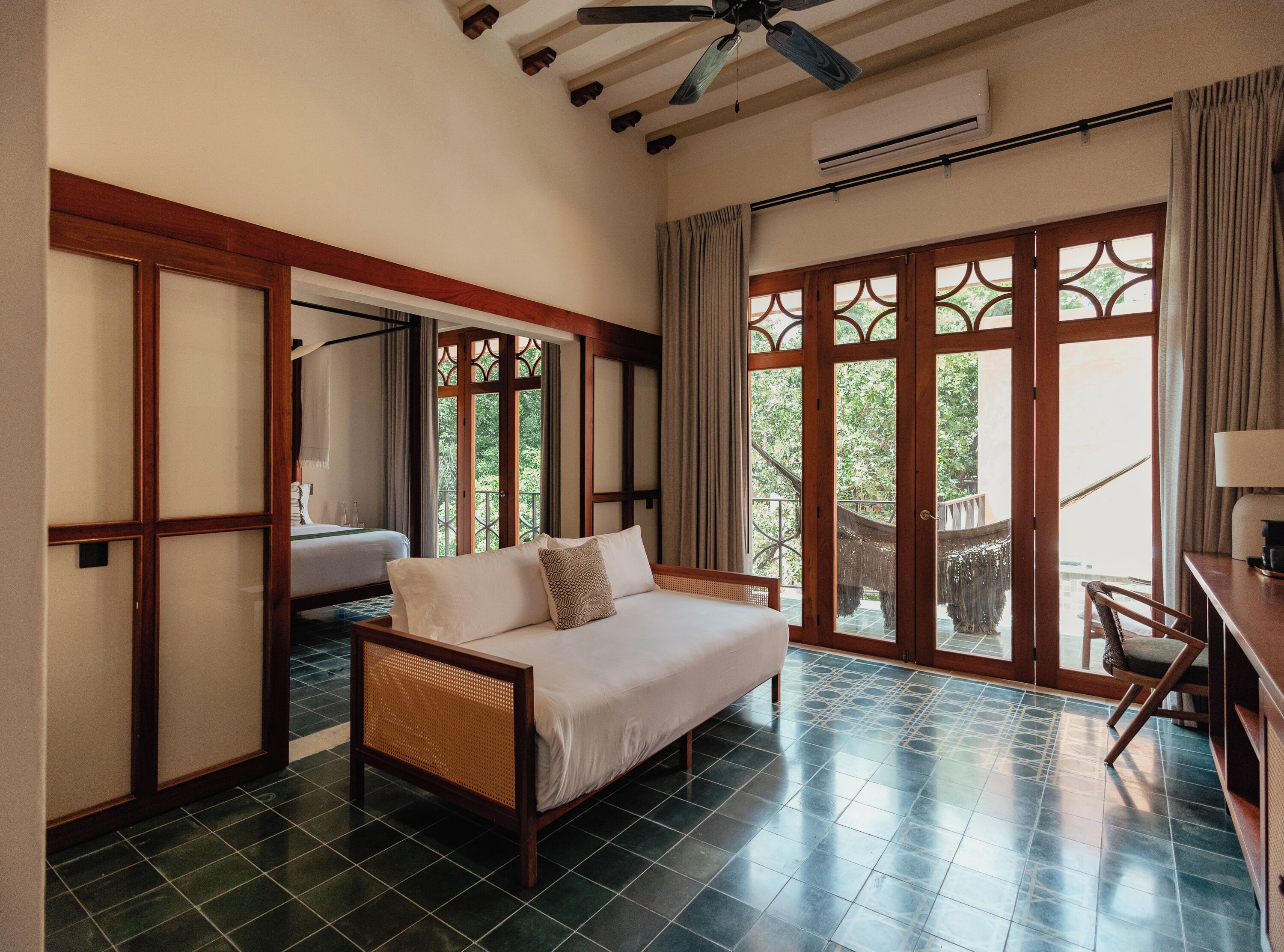 Una habitación con cama, escritorio y vistas a zonas verdes.
