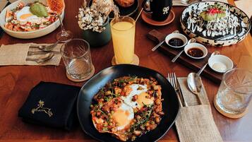 A breakfast setting with a plate of eggs, toast, and a glass of orange juice.