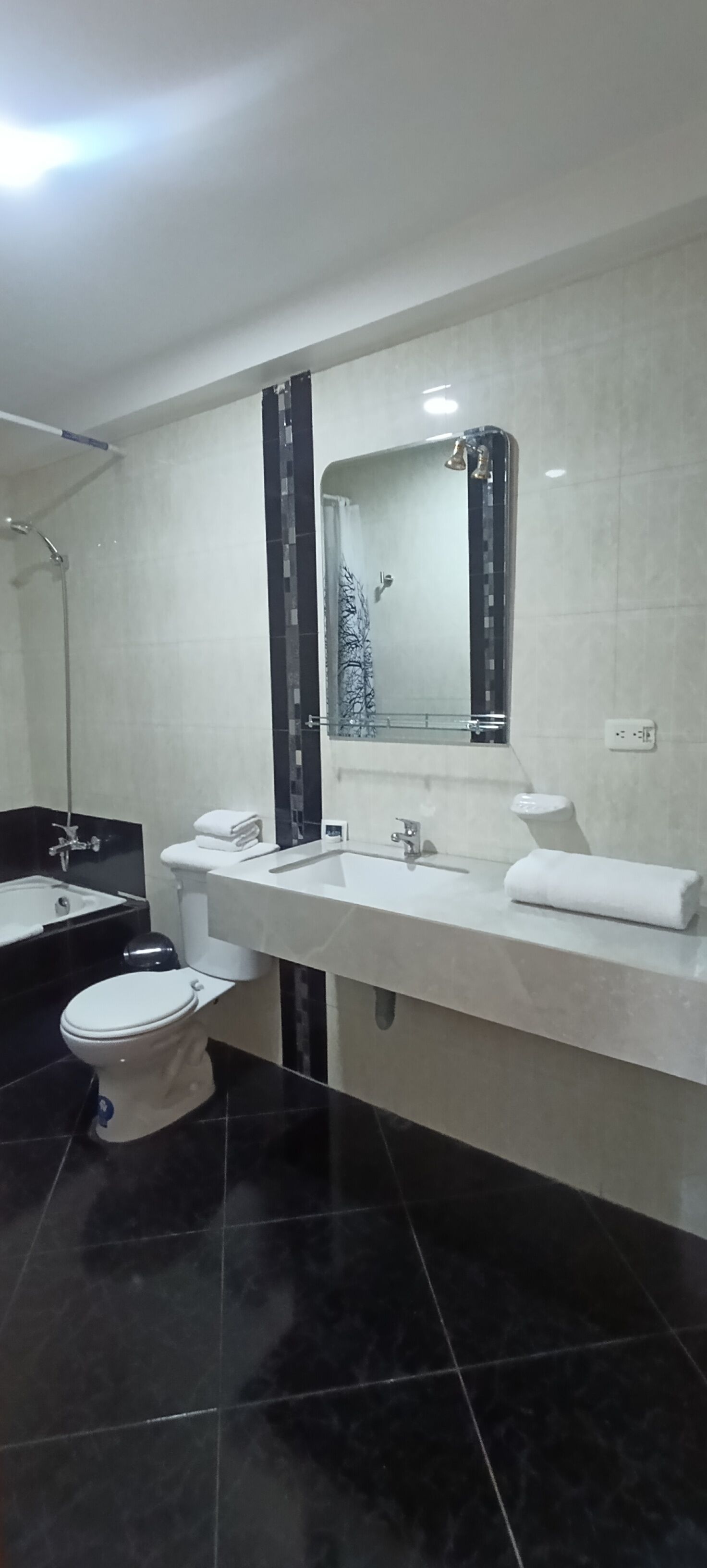Ein modernes Badezimmer mit einem weißen Waschbecken, einer Toilette und einer Duschkabine.