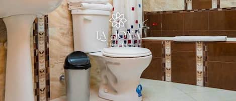 A bathroom with a sink, toilet, and shower area.