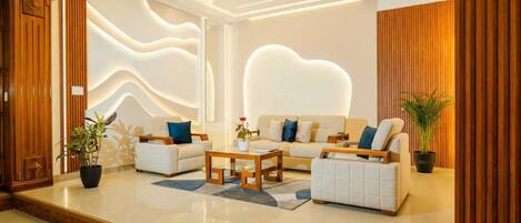 A modern living room with a sofa set, a coffee table, and decorative plants.
