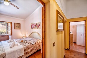 A bedroom with a bed, a window, a painting, and a door leading to another room. - Tuscany Apt Marco Private Pool&Tennis 6, Loro Ciuffenna, Italy (Loro Ciuffenna)