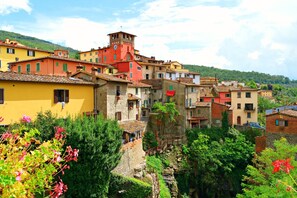 A hillside village with colorful buildings, a prominent tower, and lush greenery. - Tuscany Apt Marta Private Pool&Tennis 6, Loro Ciuffenna, Italy (Loro Ciuffenna)