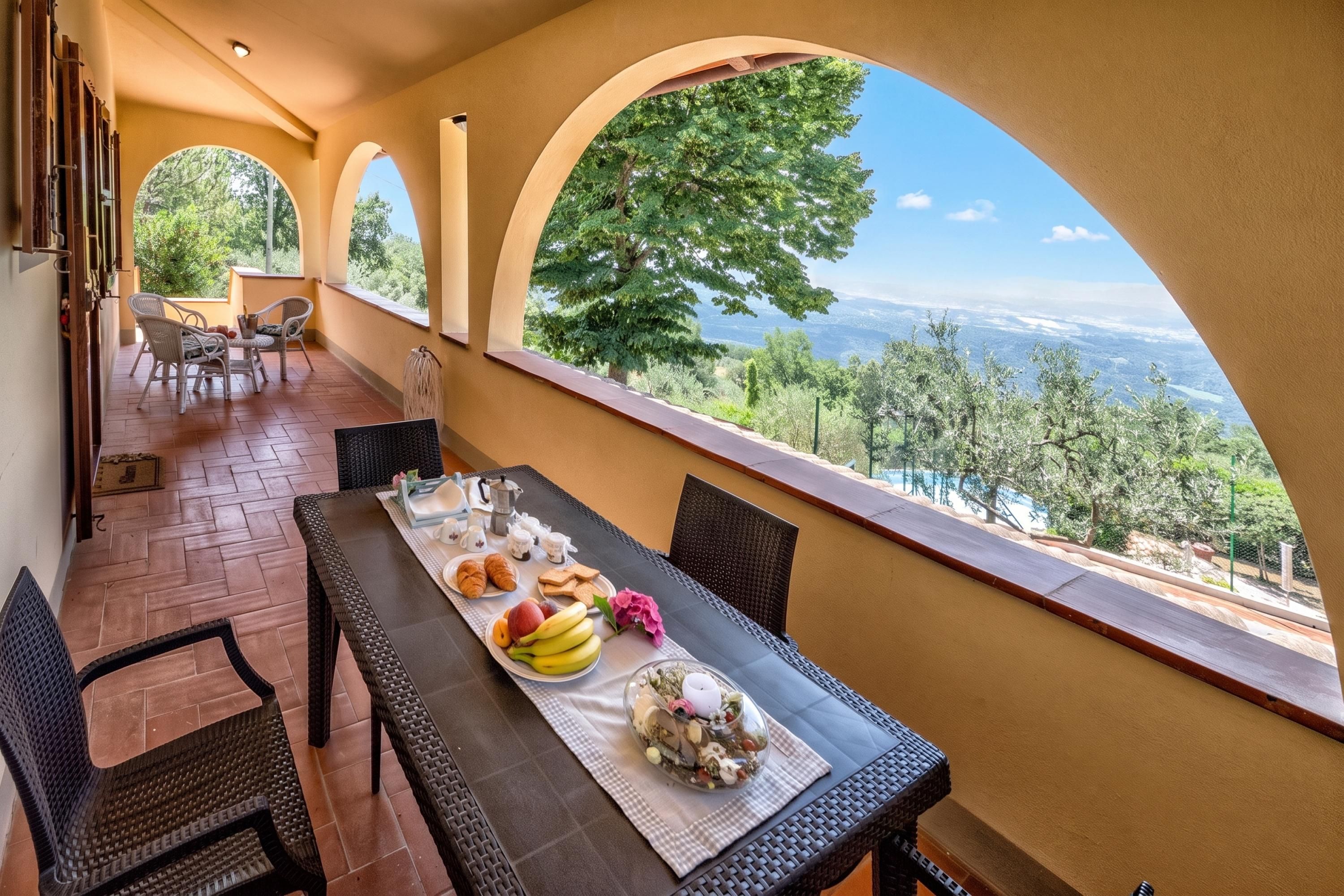 Une terrasse avec une table préparée pour le petit-déjeuner, offrant une vue sur un paysage magnifique.