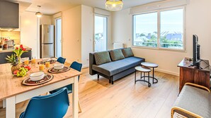 A modern apartment with a dining area, kitchen, sofa, and a balcony with a view. - Ar Marine by Interhome (Quiberon)