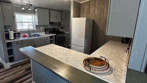 Una cocina moderna con encimera de mármol, horno empotrado y refrigerador.