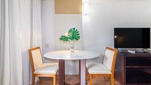 A hotel room with a round dining table, two chairs, a TV, and a plant. - Leoncio 706 in S o Paulo (São Paulo)