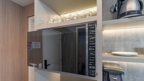 A modern kitchen with a built-in coffee machine, a water dispenser, and a digital menu display. - Melo Alves 32 2p 1q (São Paulo)