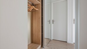 A walk-in closet with wooden shelving and a mirrored closet door. - Blueground | Chaillot, city view, nr Eiffel Tower (Paris)