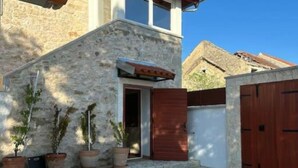A stone building with a wooden door and a small porch area with potted plants. - The Grandfather Villa Heated Pool Retreat (Stankovci)