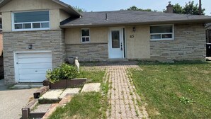 A single-story house with a garage, a front door, and a brick pathway leading to the entrance. - Cozy Home in North York Toronto (Toronto)