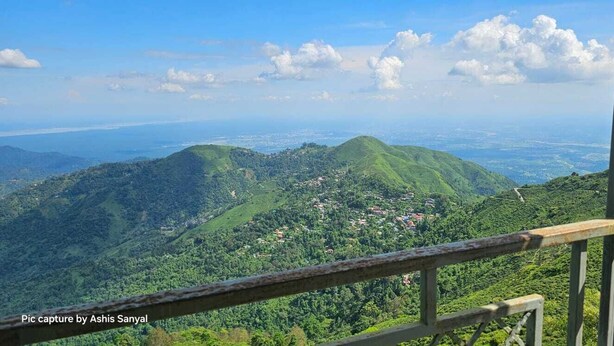 Vista panorámica desde un punto elevado sobre un valle exuberante y verde con un pequeño pueblo abajo.