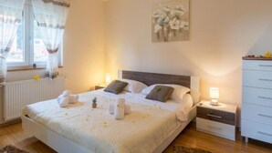 A neatly arranged bedroom with a bed, bedside tables, a dresser, and a window with curtains. - Holiday House Balen With Swimming Pool (Benkovac)