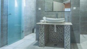 A modern bathroom with a glass shower enclosure, a white sink with a mosaic tile base, and a large mirror above the sink. - Holiday House Balen With Swimming Pool (Benkovac)