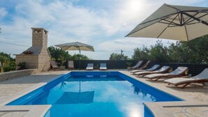 A rectangular swimming pool with lounge chairs and umbrellas. - Holiday House Balen With Swimming Pool (Benkovac)