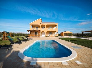 A two-story building with a swimming pool in front. - Villa Maja (Škabrnja)