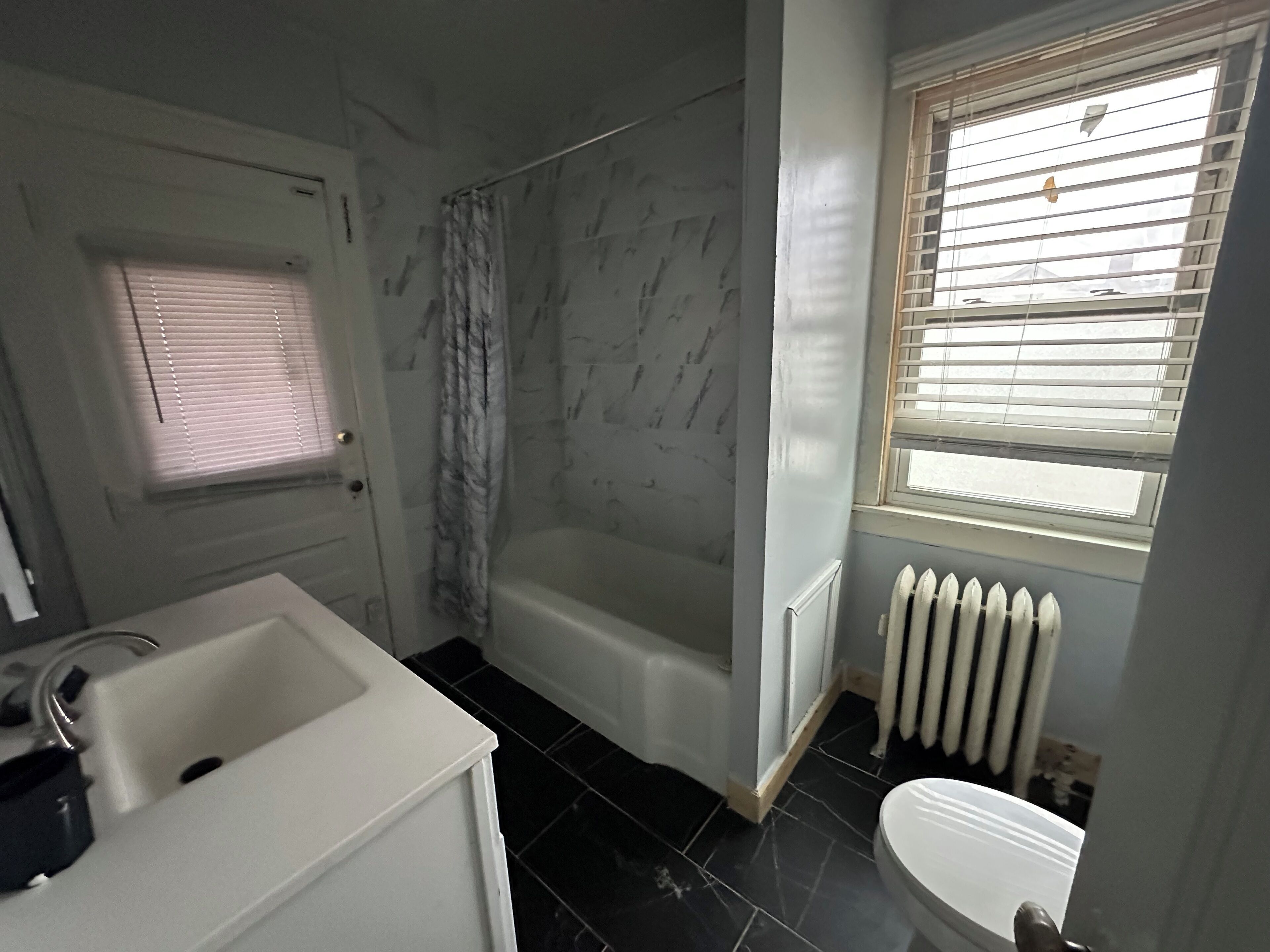 A bathroom with a bathtub, a sink, and a toilet.