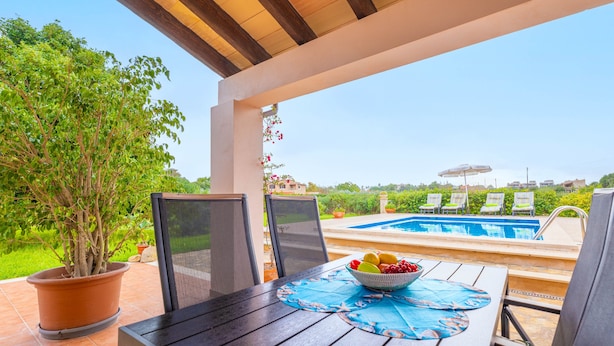 A patio with a pool, chairs, and a table with fruit. - SA PLANA DE BAIX - Cozy house in Son Servera with free wifi. (Son Servera)
