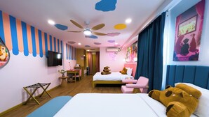 A hotel room with a bed, a desk, a chair, a ceiling fan, and a television. - Casa de Capybara (Siem Reap)