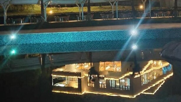 Un bâtiment moderne à deux étages, avec une piscine en premier plan.