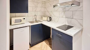 Eine kleine Küche mit Mikrowelle, Toaster, Wasserkocher und Geschirrspüler.