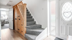 A staircase with wooden railings and carpeted steps leading to a door with a heart-shaped window. - 4 bedroom accommodation in California (California)