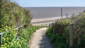A pathway leading to a beach with a fence on one side and vegetation on the other. - 4 bedroom accommodation in California (California)