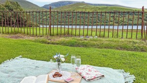 Una disposición para picnic en un área verde con vistas a un lago y colinas.