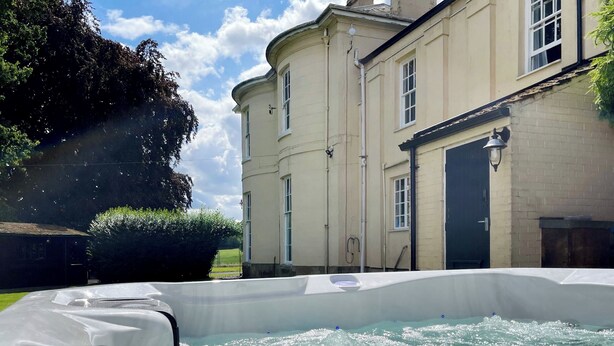 A hot tub in front of a building with a door and windows. - 6 bedroom accommodation in Market Rasen (Market Rasen)
