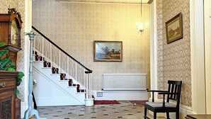 A grand staircase with a white railing, a radiator, and a painting on the wall. - 6 bedroom accommodation in Market Rasen (Market Rasen)