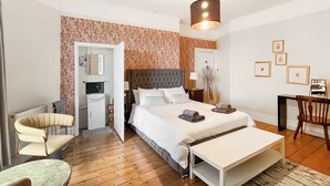 A modern hotel room with a large bed, a sitting area with a table and chairs, a small kitchenette, and a bathroom. - 6 bedroom accommodation in Market Rasen (Market Rasen)