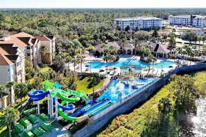 A resort with a large swimming pool, water slides, and a view of surrounding buildings and greenery. - Lilo & Stitch–Themed Condo-2 miles from Disney! (Kissimmee)