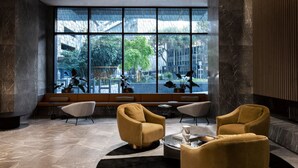 A modern lobby with a large window, seating area, and marble flooring. - West Side Place Family Suite w/ Pool+Sauna+Gym (Melbourne)