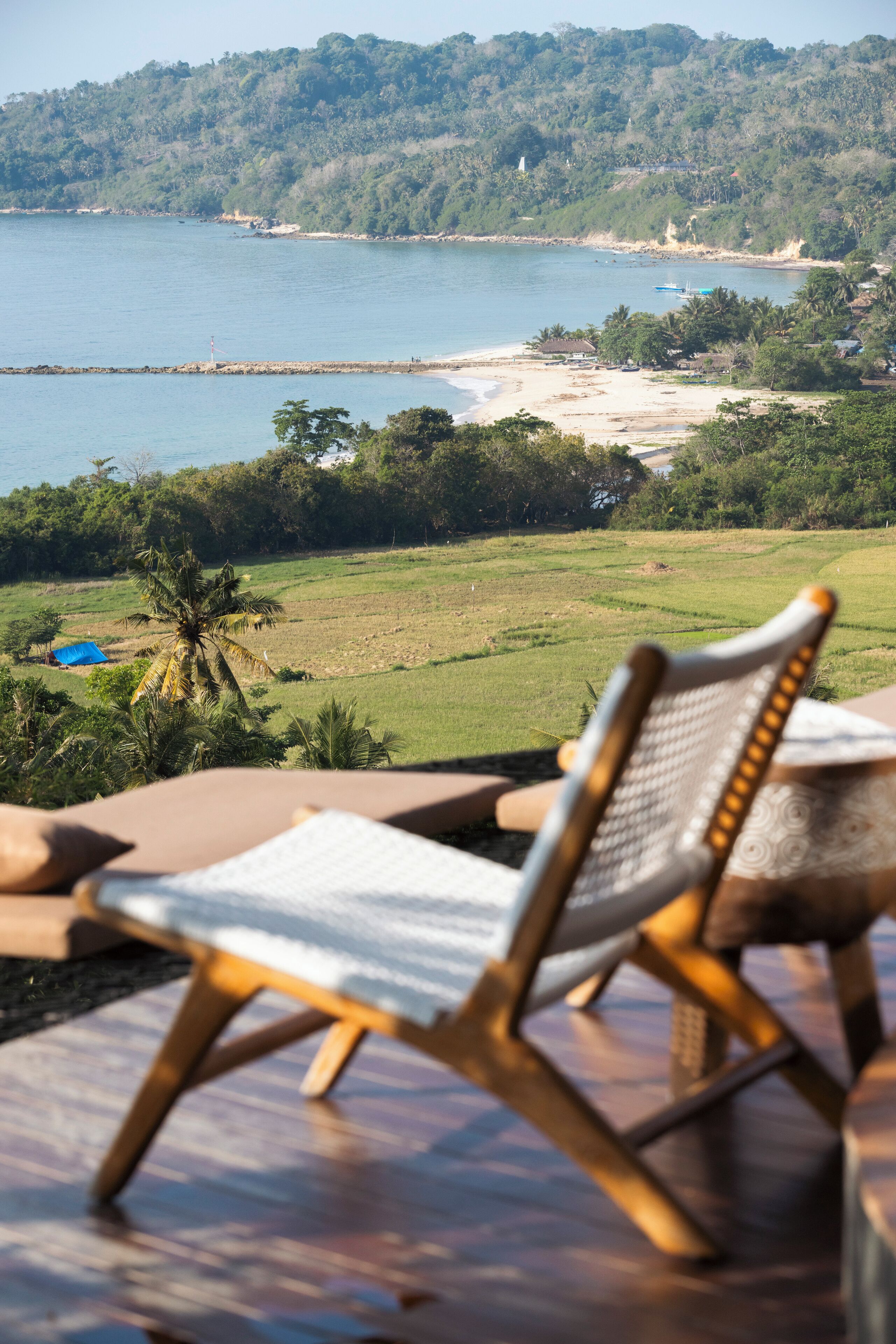 Vista da praia com uma cadeira em primeiro plano.