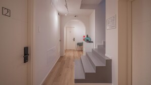 A hallway with a staircase, a door with a number, and a small seating area with a table and chairs. - DIMORA IN PRATO (Padova)