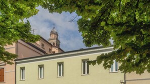 A building with a light facade, multiple windows, and a dome structure in the background. - DIMORA IN PRATO (Padova)