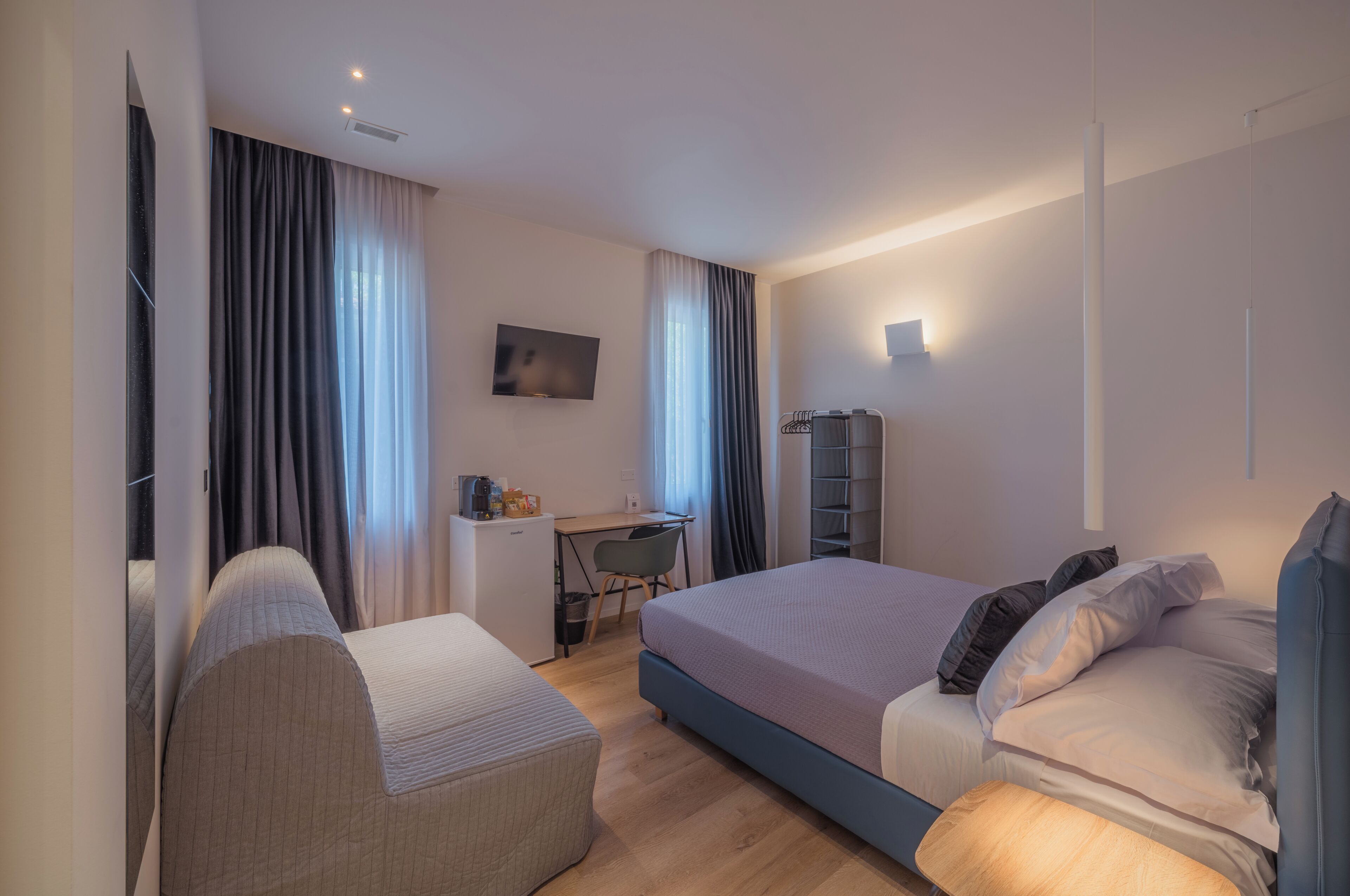 Une chambre d’hôtel moderne avec un grand lit, un bureau et une télévision.