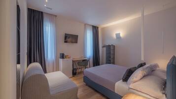 Une chambre d’hôtel moderne avec un grand lit, un bureau et une télévision.