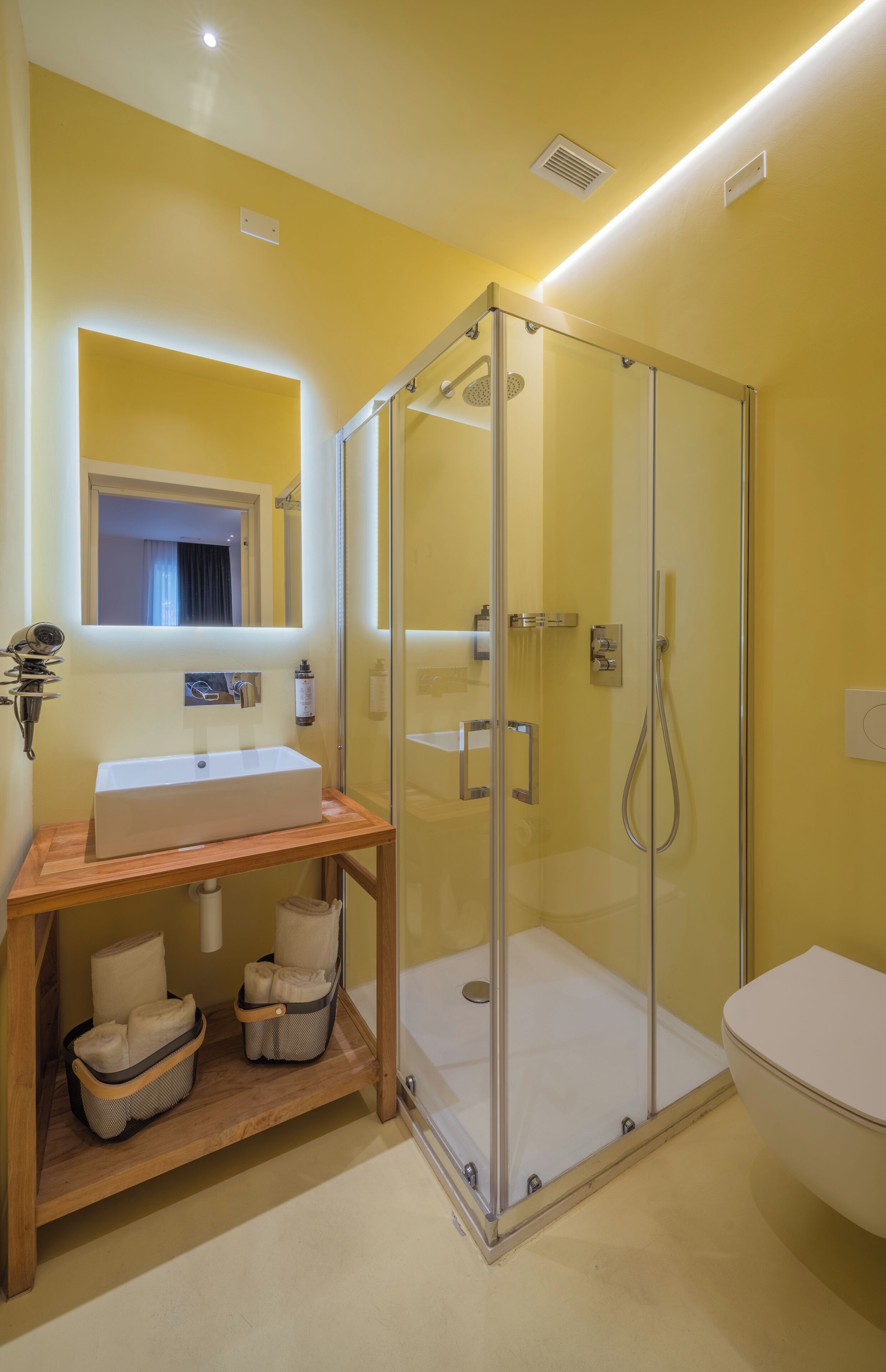 Un bany amb dutxa trencada per vidre, un lavabo amb un mirall a sobre i un vàter.