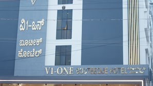 Un hôtel moderne, reconnaissable à son enseigne bien visible indiquant « VI-ONE Boutique Hotel ».
