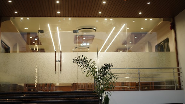 Un intérieur moderne avec un plafond en bois, des murs en verre et un escalier menant à un niveau supérieur.