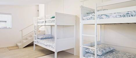 A bunk bed room with a staircase and a ceiling fan.