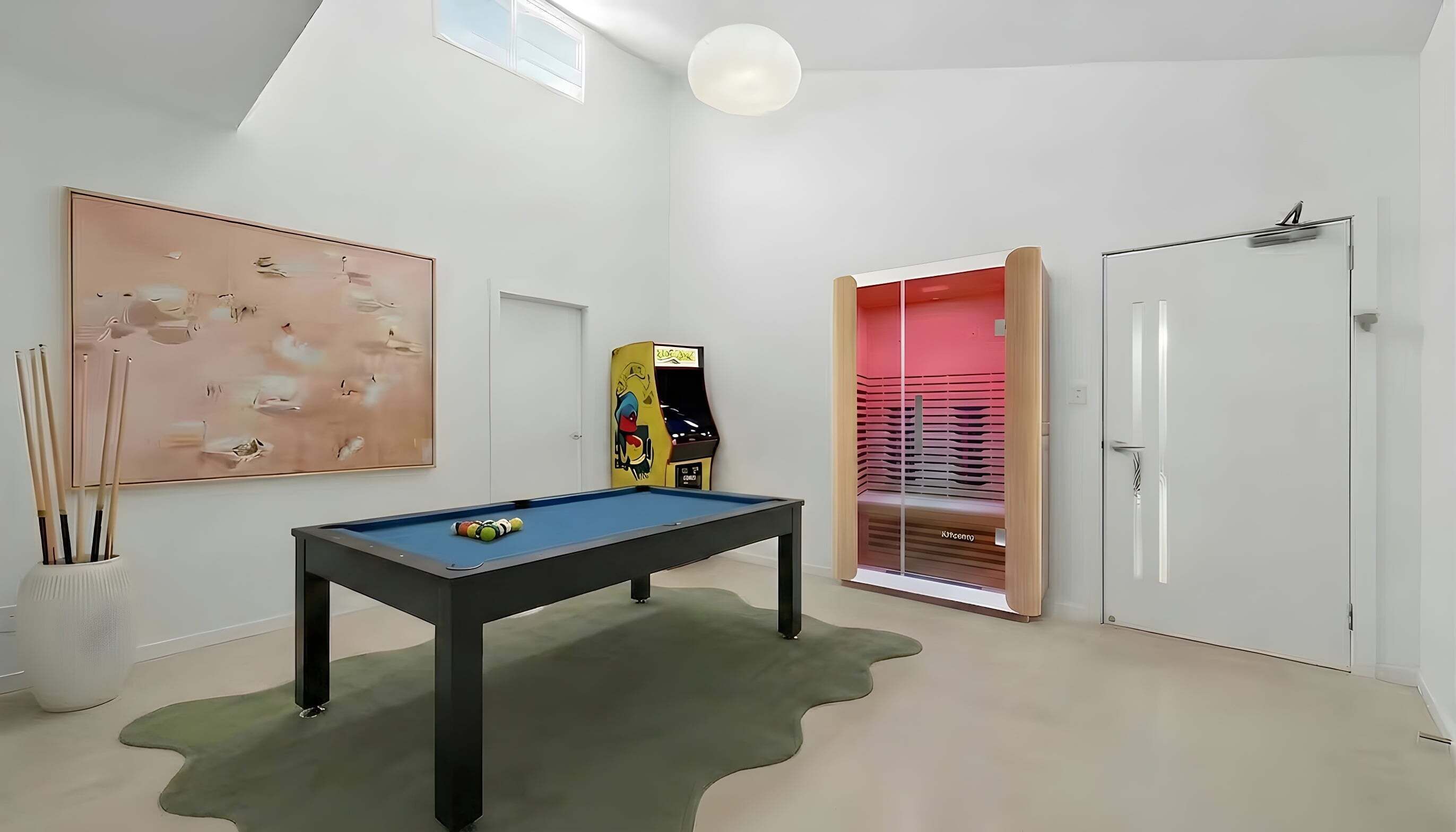A room with a pool table, a painting, a jukebox, and a door leading to a red room.