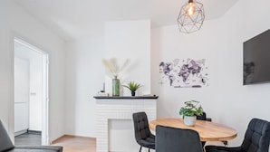 Uma sala de estar moderna com lareira, uma mesa de jantar com cadeiras e um grande mapa-múndi na parede.