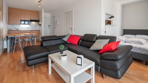 Un appartamento moderno con zona giorno, angolo cottura e camera da letto.
