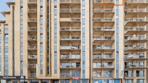 Un edificio a più piani con balconi e un ristorante a livello strada chiamato "Saltwaters".